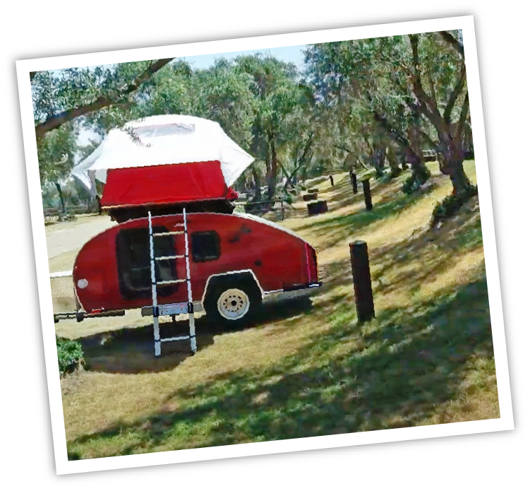 red camping trailer with a ladder extending to its rooftop tent